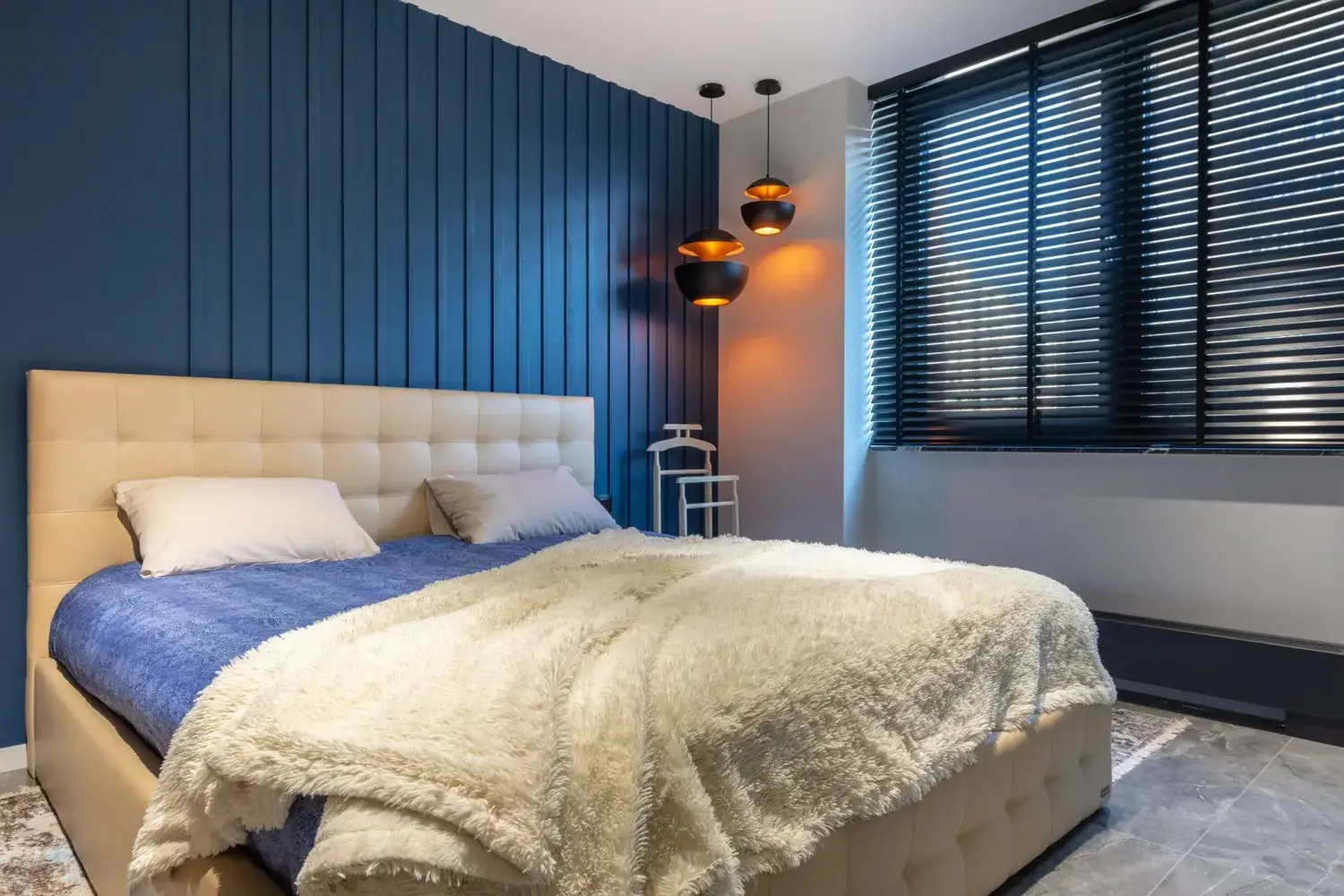 Dark aluminium venetian blinds across bedroom windows