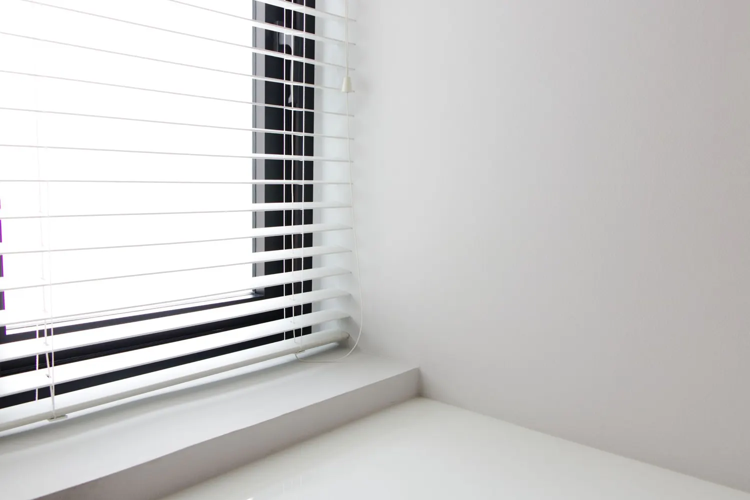 White blind fitted neatly inside a uPVC window frame